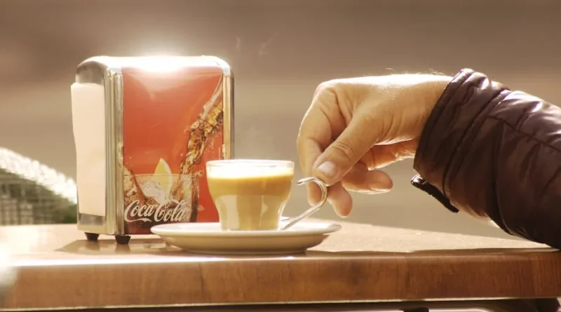 Traveler enjoying a quiet morning at a local café in a European village slow travel style