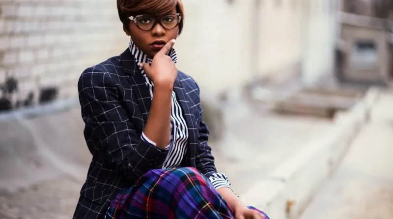 A woman confidently wearing a well-fitted, stylish one-piece swimsuit on a sunny beach.