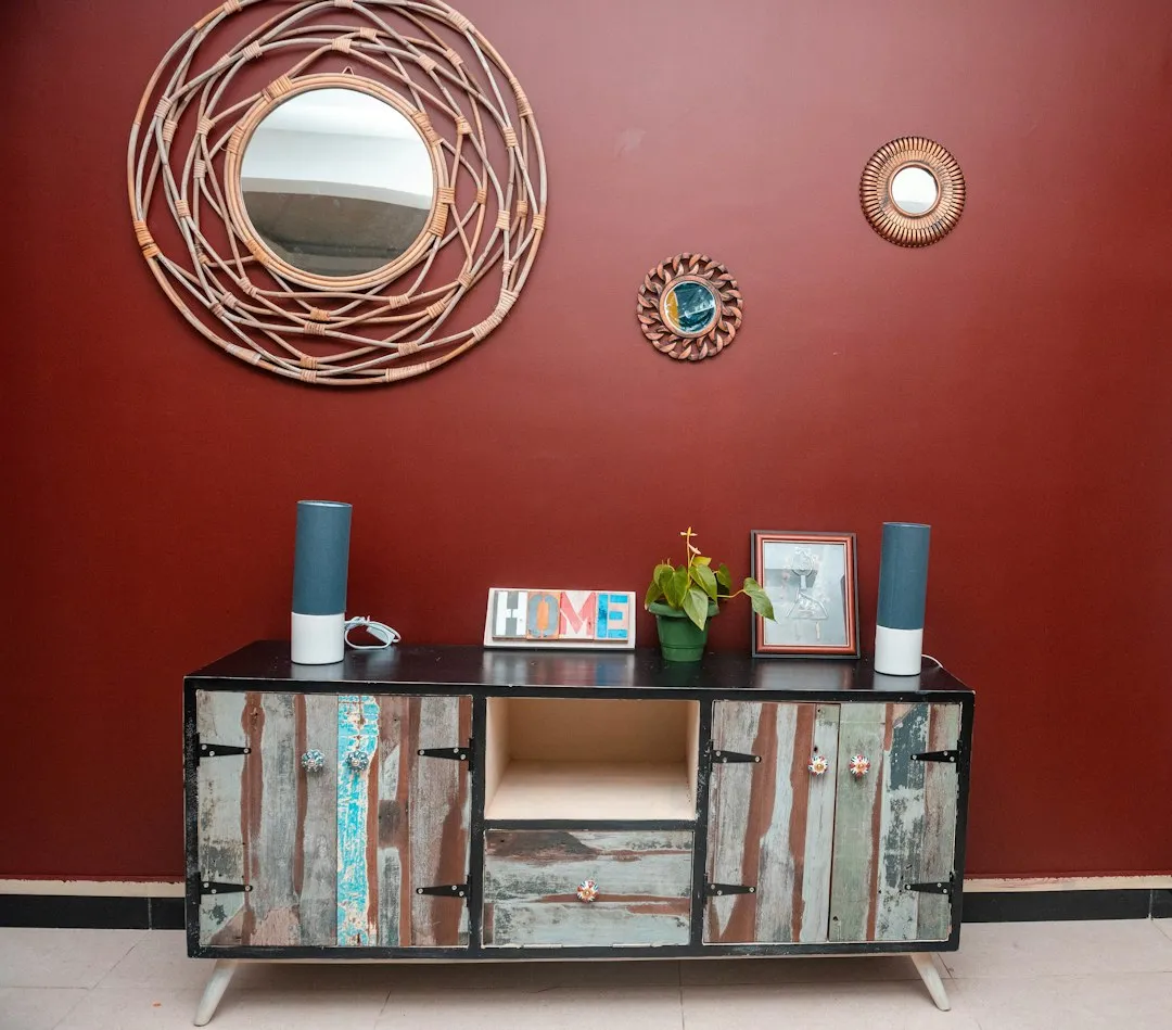 Framed artwork alignment diagram above a wooden living room sideboard